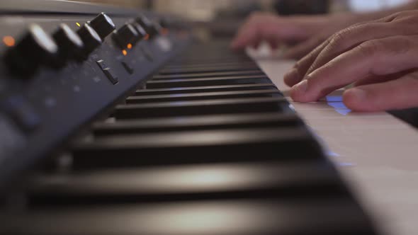 Close up on musician's hands, playing a synthesizer, shallow depth of field , bokeh 4k shot on a ful