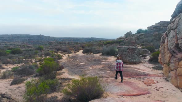 Man walking through the rock formations 4k