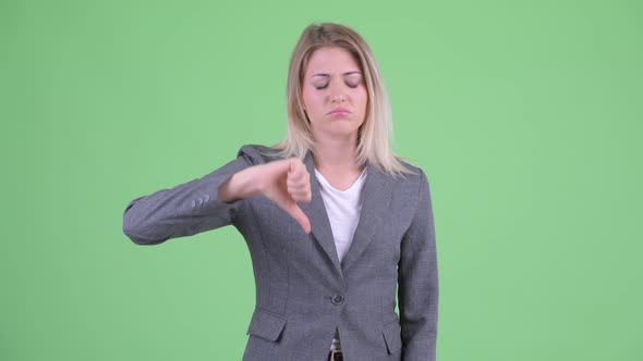 Sad Young Blonde Businesswoman Giving Thumbs Down