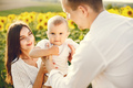 Mother, father and son in white clothes at the sunflowers field - PhotoDune Item for Sale