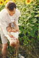 Father playing with his son while standing in the sunflowers field - PhotoDune Item for Sale