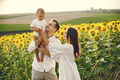 Mother, father and son in white clothes at the sunflowers field - PhotoDune Item for Sale