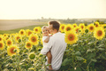 Father hugging his son while standing in the sunflowers field - PhotoDune Item for Sale