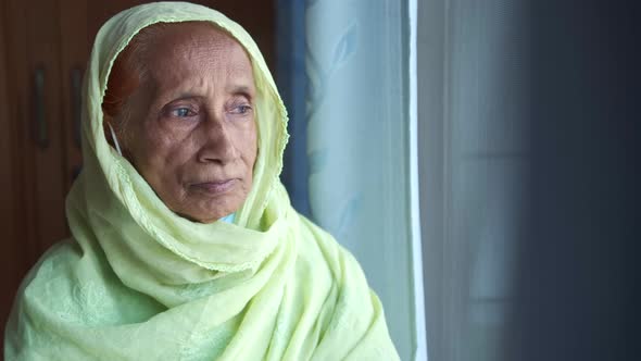 Depressed Senior Women Looking Through Window