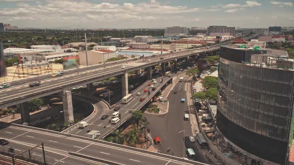 Manila City Roadway with Cars and Trucks at Modern Buildings Aerial View