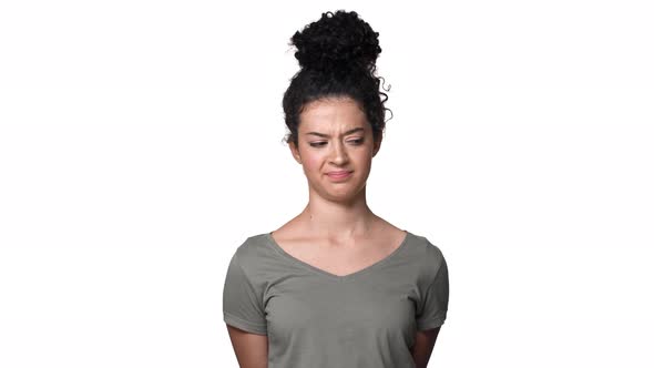Portrait of Modest Young Woman 20s with Curly Hair in Bun Shaking Head and Expressing Denial or