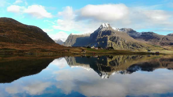 Drone flys backwards, revealing a mountain and a lake