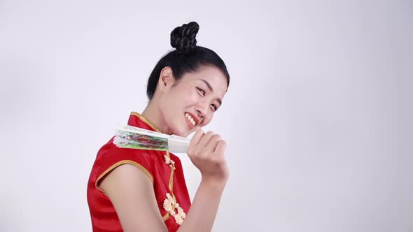 woman wearing chinese cheongsam dress and holding a chinese fan