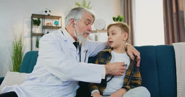 High-Skilled Respected Doctor Examining Boy Patient's Breath using stethoscope