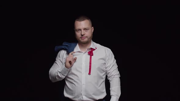 A Man with a Beard in a White Shirt and a Jacket on His Shoulder Points His Finger Forward