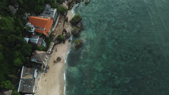 Beautiful Bingin beach with exotic cliffs houses and hotel located in Bali, Indonesia. This drone fo