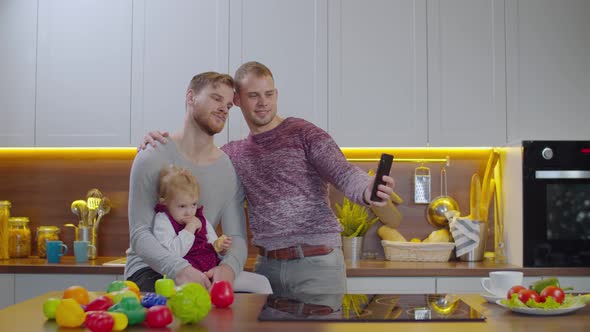 Cheerful Gay Parents with Baby Taking Selfie Shot