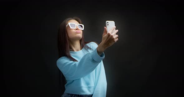 Young Asian Woman Makes Faces in Front of a Smartphone Taking Stupid Selfies