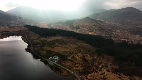 Looscaunagh Lough, Killarney, Kerry, Ireland, March 2022. Drone pushes above the lake under a moody