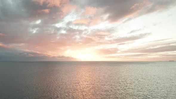 Epic Sunset over Pacific Ocean, flying backwards over open sea during sundown