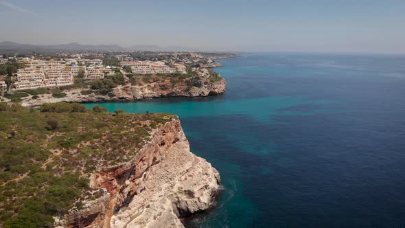 AERIAL: Drone flying close to cliffs of mallorca coast in sunny summer