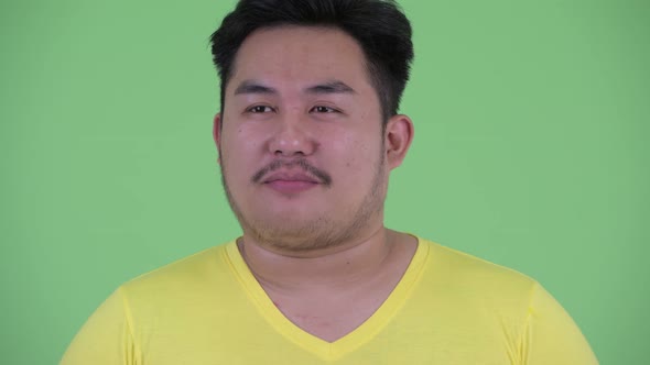Happy Young Overweight Asian Man Talking To Camera