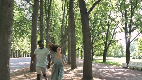 AfroAmerican Man and Brunette Woman Run Joining Hands