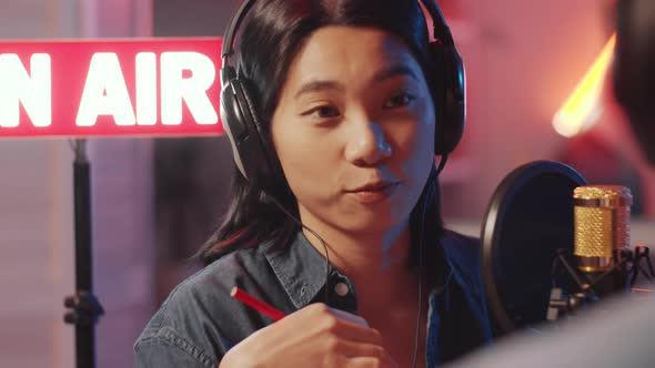 Young Asian Woman Hosting Radio Interview in Studio