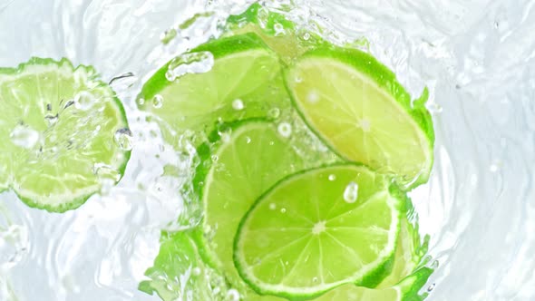 Super Slow Motion Shot of Lime Slices Falling Into Water Whirl at 1000 Fps