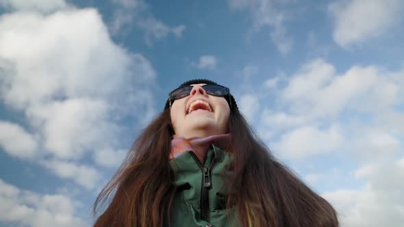 Smiling Darkhaired Woman in Dark Glasses Communicates with the Interlocutor