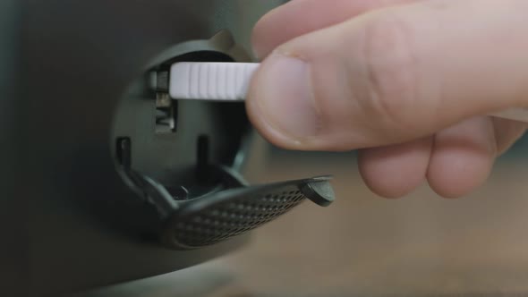 Man Inserting a White Cable Into the USB Socket of a Computer Which is on the Office Table