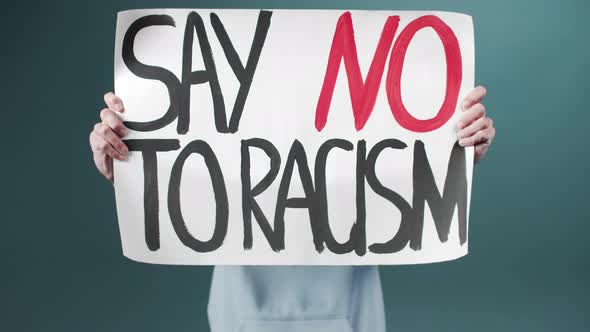 A Young Man in a Blue Hoodie Keeps a Poster Against Racism Closeup Details