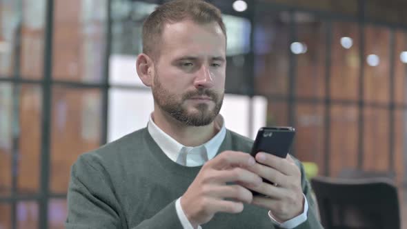 Portrait Shoot of Disappointed Man Using Cellphone