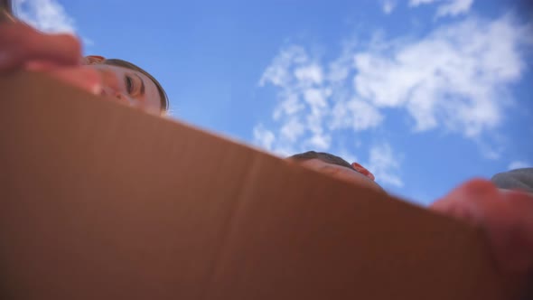 A Young Guy and a Girl Open the Box Together. The Guy Gives a Gift.