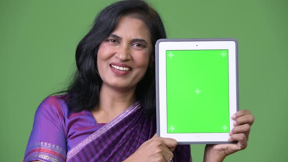 Mature Happy Beautiful Indian Woman Smiling While Showing Digital Tablet