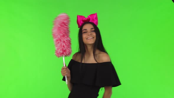 Young Beautiful Woman Wearing Pink Bow Posing with a Duster
