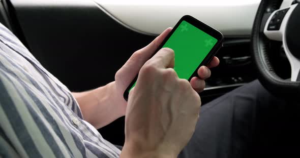 Smartphone green mock-up screen, man driver doing tapping gestures.