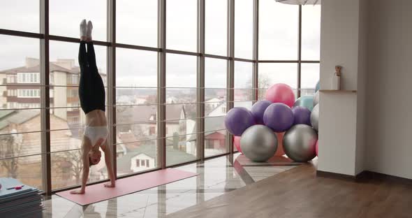 Athletic Woman Stretching on a Mat in a Fitness Studio