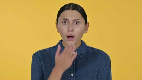 Latin Woman Feeling Shocked, Yellow Background 