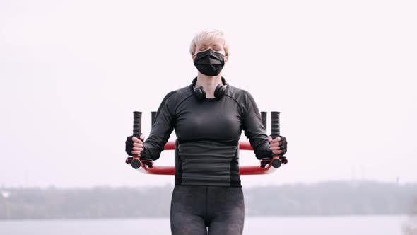 The Sporty Woman in a Protective Mask Is Doing Workout in a Park