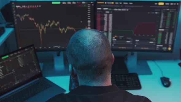 Mature Male Stock Market Trader or Broker Analyzing Graphs on Multiple Computer Screens
