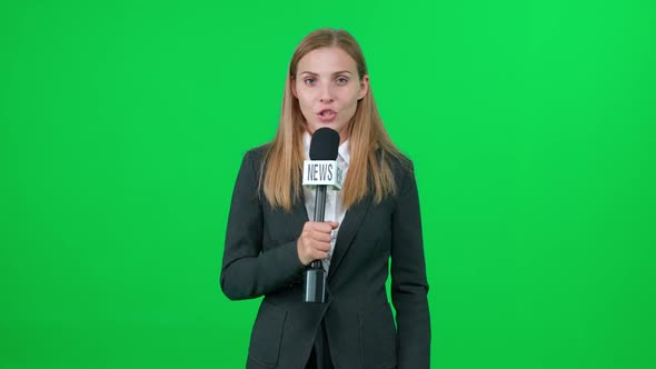 Breaking News Caucasian Female News Reporter Speaks Into a Microphone on a Green Background and