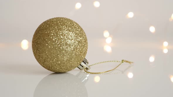 Gold color Christmas tree ornament with fairy lights slow tilt 4K 2160p 30fps UltraHD footage - Gold