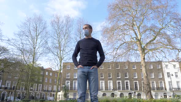 Young man alone with face mask on in London - Man wearing a medical mask at p