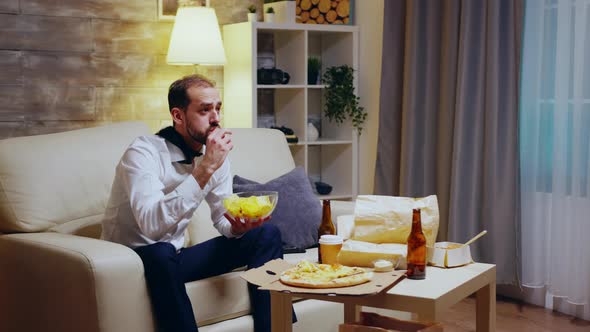 Tired and Excited Entrepreneur with Tie Eating Chips