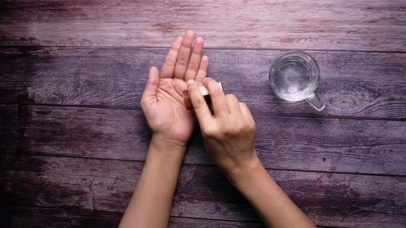 High Angle View of of Pills on Palm of Women Hand 