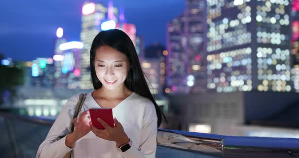 Woman use of mobile phone in Hong Kong at night