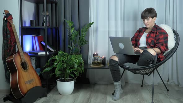 Young beautiful woman is working on laptop computer in cozy comfort living room at home. 