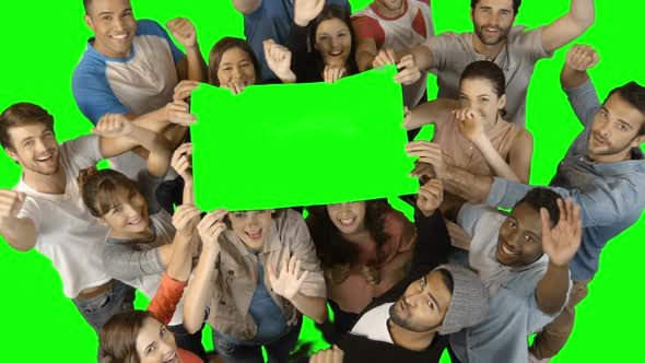 Overhead view of excited executives holding blank green placard