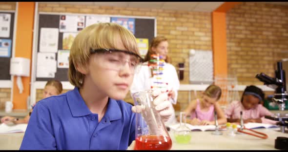 Schoolboy doing chemical experiment in laboratory