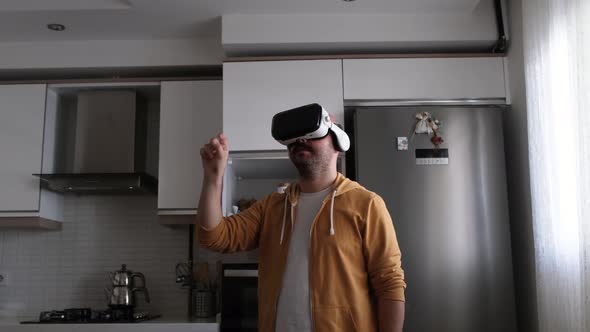 Young man walking around virtual market with vr glasses in kitchen.