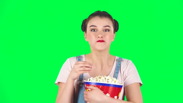 Sweet Girl Chews Popcorn While Watching a Movie. Girl Watching with Spellbound, Slow Motion