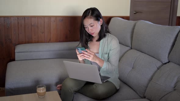 Asian woman with latte touching screen on smartphone