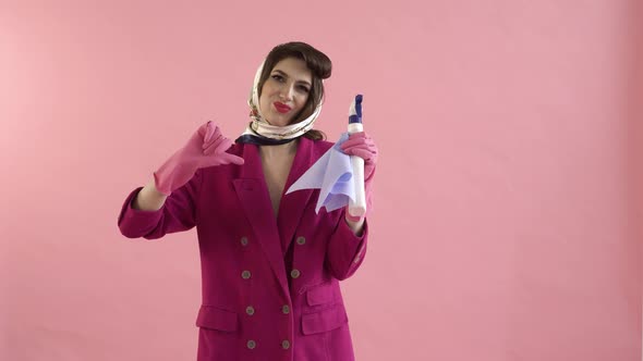 A Gloved Woman Holds a Window Cleaner Spray and Shows a Thumbsdown Gesture