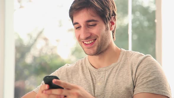 Man text messaging on cell phone
